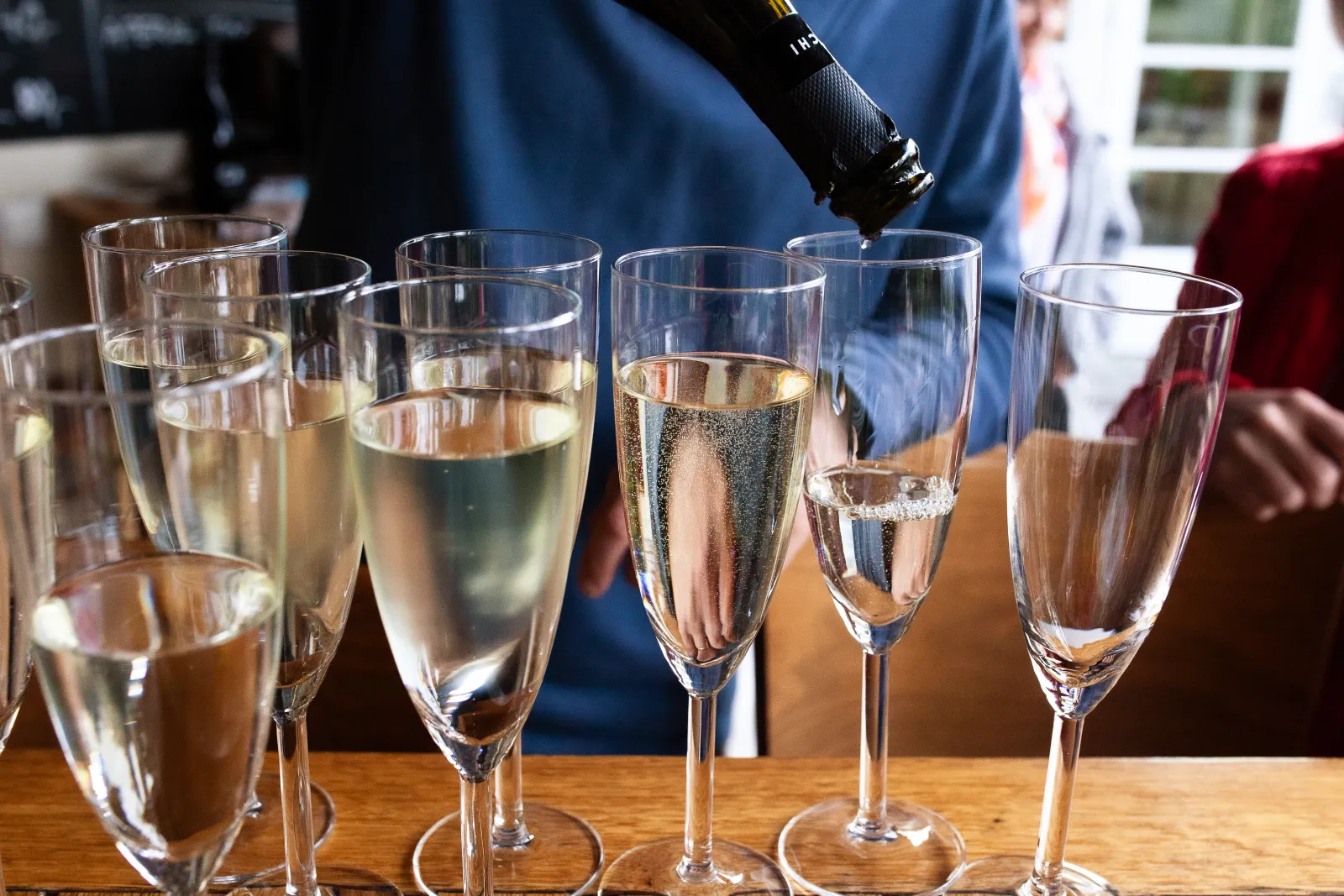 Einschenken von Sekt in Gläser